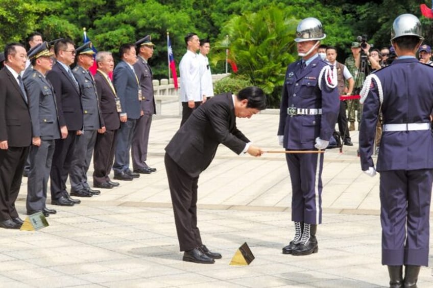 Taiwanese President Lai Ching-te (C) presents incense during an event marking the 66th ann