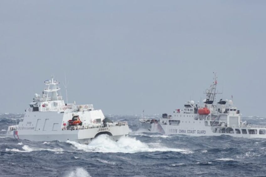 A Taiwanese coast guard ship (L) sails near a Chinese vessel a few nautical miles from Tai