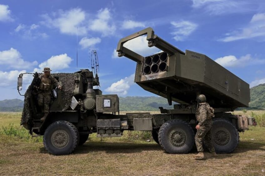 US Marine officers stand next to a HIMARS during live fire exercises with the Philippine M