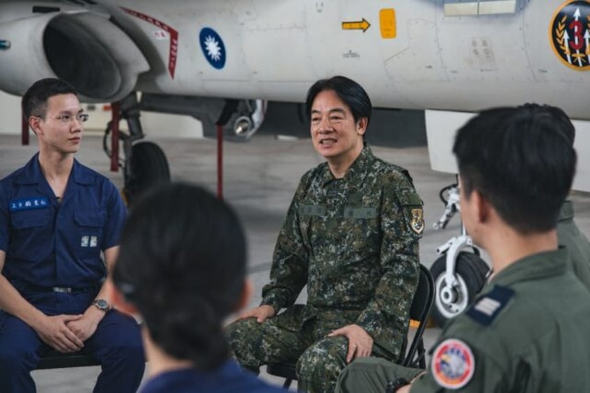 Handout photo taken and issued on July 9, 2024 shows Taiwan's President Lai Ching-te (C) i