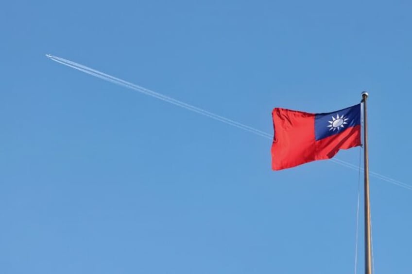 A Taiwan flag flies over the capital, Taipei, in October 2024. The self-ruled island is cl