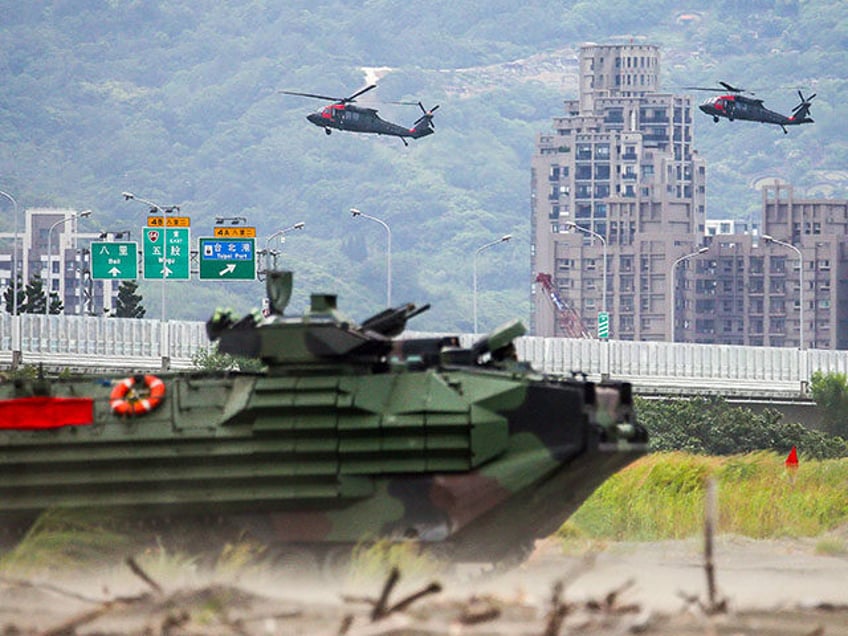 Two UH-60M Black Hawk helicopters and an assault amphibious vehicles on Bali beach during