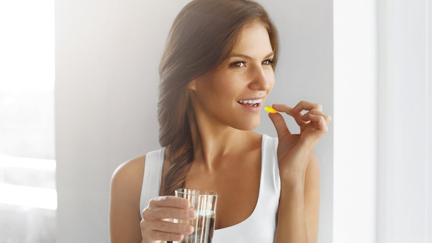 Close Up Of Happy Smiling Woman Taking Pill