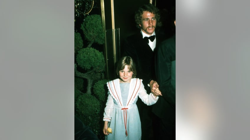 Ryan O'Neal walking with young Tatum O'Neal