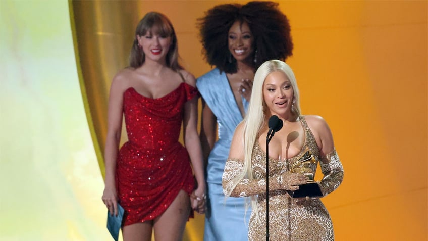 Taylor Swift stands behind Beyonce at Grammy Awards.