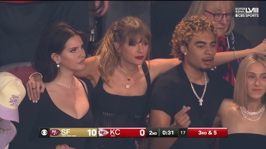 Taylor Swift with her arm around Lana Del Rey's shoulder at Super Bowl LVIII