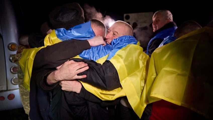 Several Ukrainian prisoners of war hug after a swap, amid Russia's attack on Ukraine, at an unknown location in Ukraine
