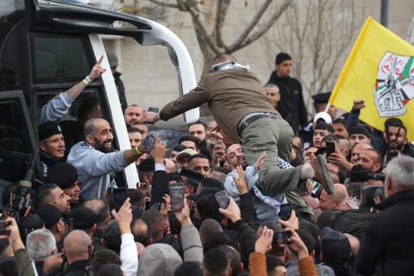 A man launches himself from the crowd to greet a returning Palestinian prisoner