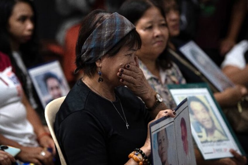 Families holding portraits of victims of former Philippines president Rodrigo Duterte's dr