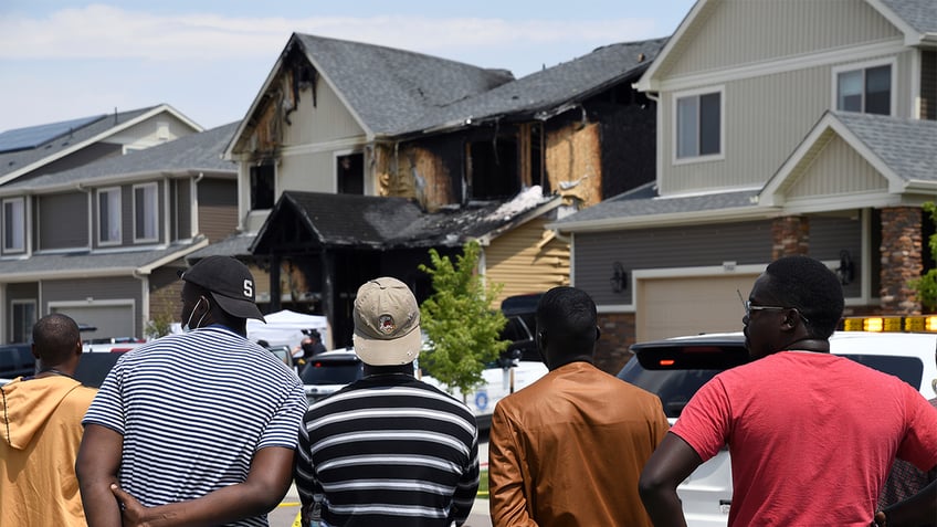 People look at a house that was set on fire in Denver