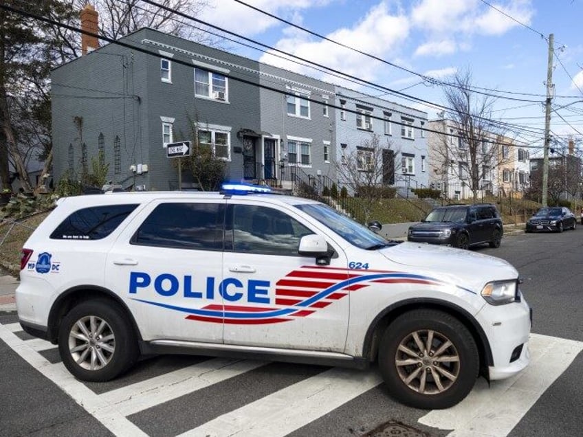 A police car blocks off a street near where a person has barricaded himself during a stand