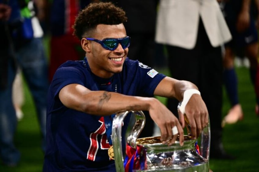 Desire Doue poses with the trophy after starring in Paris Saint-Germain's remarkable Champ