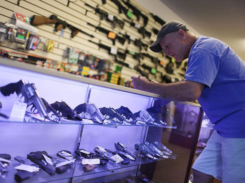 Mark O'Connor fills out his Federal background check paperwork as he purchases a handgun a