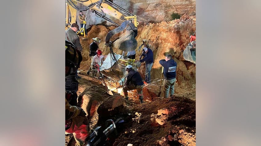 rescuers digging out buried backhoe operator