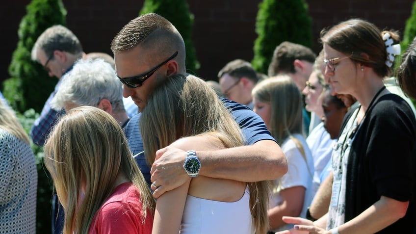 Community members at Asher Sullivan's prayer vigil hold each other, as they hope the 10-year-old pulls survives the insurmountable odds. 