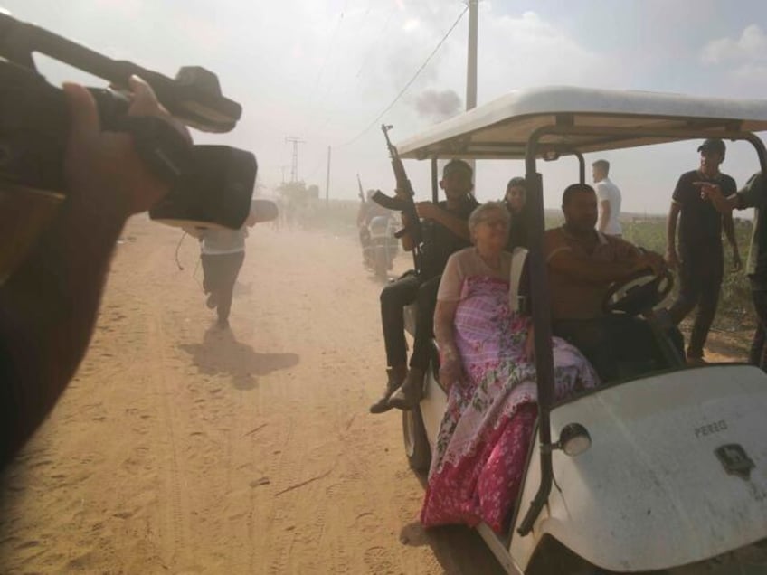 FILE - Palestinians transport a captured Israeli civilian from Kfar Azza kibbutz into the