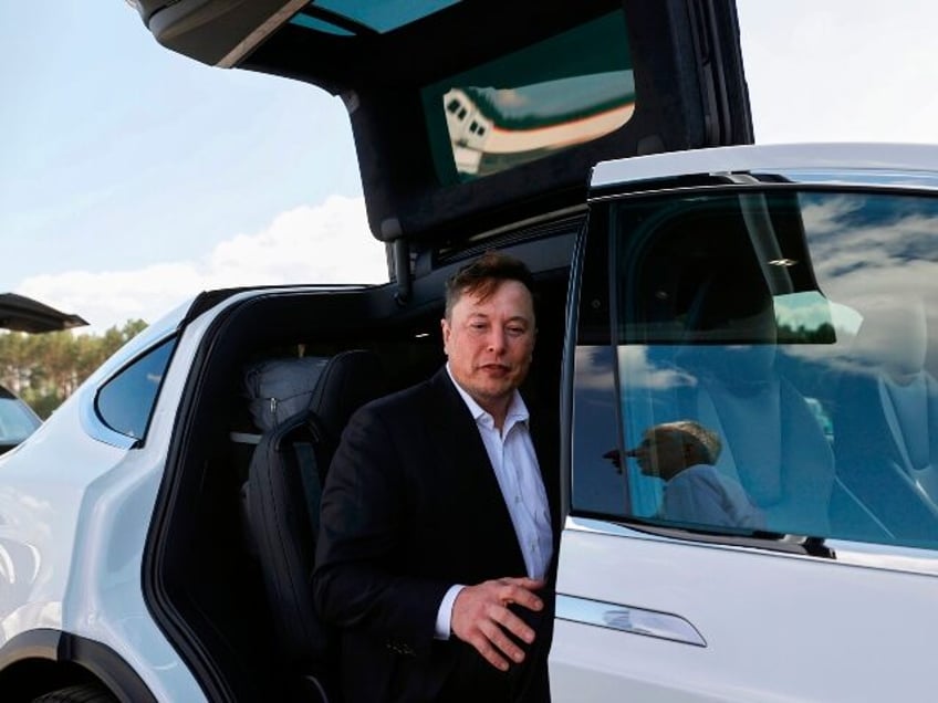 Elon Musk sits in a Model X Tesla