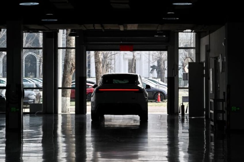 A buyer drives a new Model Y car at Tesla's Xiedao delivery centre in Beijing in February