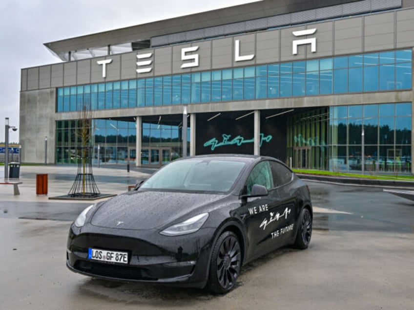 02 January 2024, Brandenburg, Grünheide: A Tesla Model Y electric vehicle stands in front of the Tesla Gigafactory Berlin-Brandenburg. The US electric car manufacturer Tesla wants to promote the planned expansion of the factory site with a "road show". The series of five information events for local residents began on …