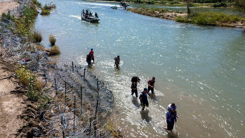 Migrants walking in water