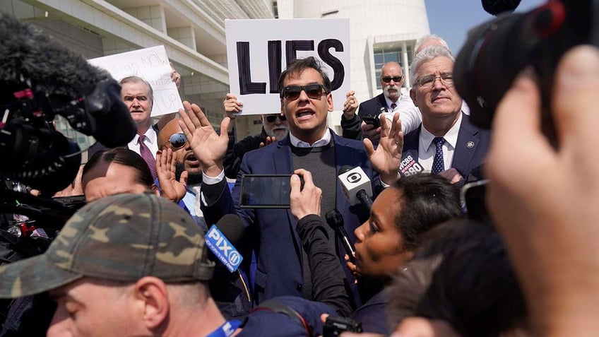 U.S. Rep. George Santos is surrounded by media as he leaves the federal courthouse