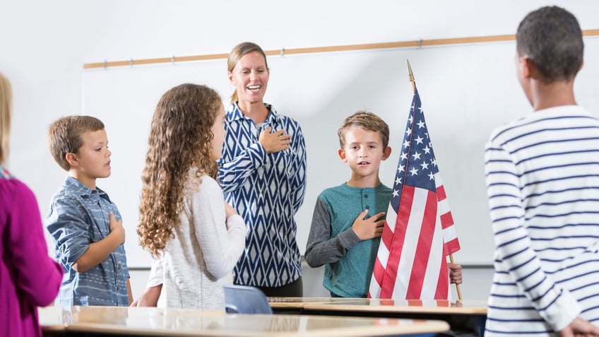 Teacher and students saying the Pledge of Allegiance.