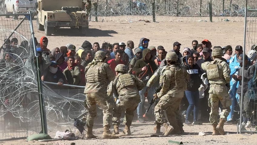 Migrants storming border gate in El Paso