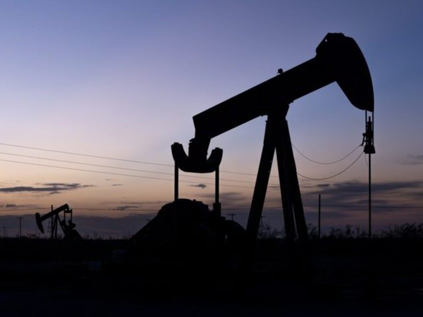 The hints of sunlight begin to disappear behind a pair of pumpjacks Wednesday, Sept. 15, 2