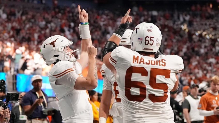 Texas Longhorns quarterback Quinn Ewers (3) celebrates with teammates after scoring a touchdown against the Arizona State Sun Devils during the second half of the Peach Bowl at Mercedes-Benz Stadium. 