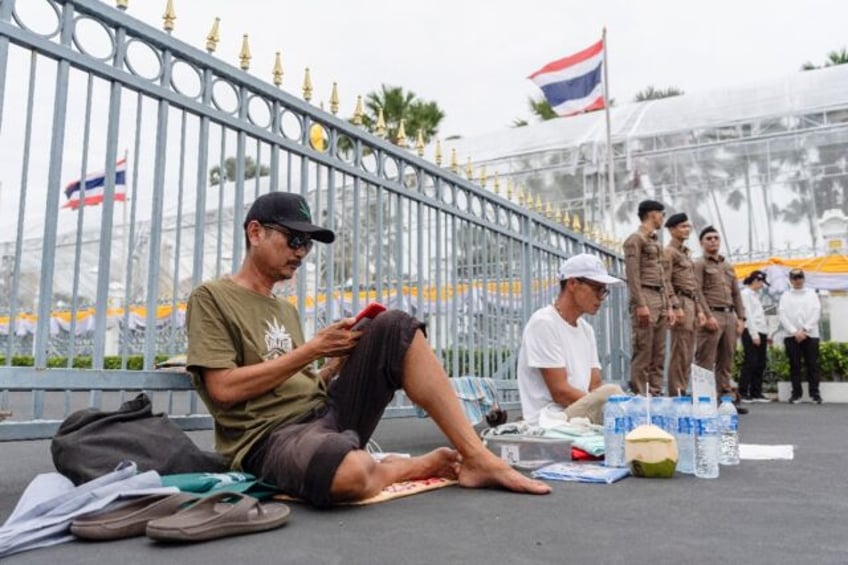 Pro-cannabis activists Akradej Chakjinda (left) and Prasitchai Nunuan sit outside Governm