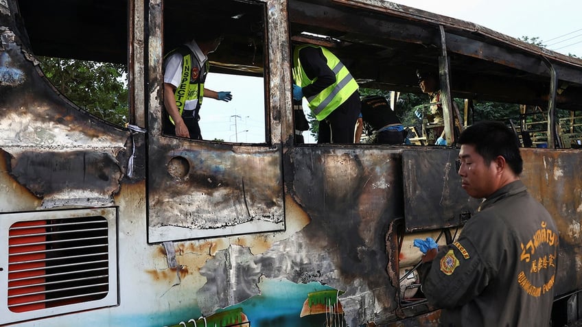 rescue workers aboard scorched bus