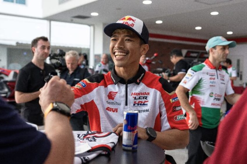 Thai rider Somkiat Chantra smiles as he signs autographs at a MotoGP launch event in Bangk