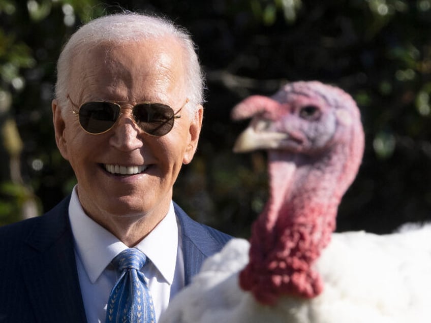 President Joe Biden stands with one of the national Thanksgiving turkeys, Peach, during a