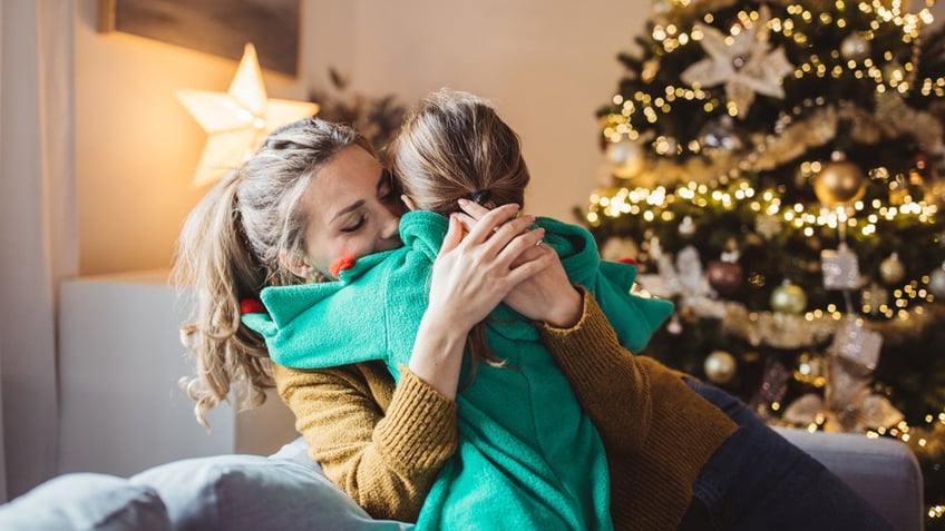 mom hugs daughter on christmas