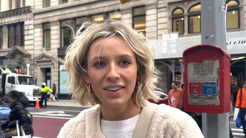 Women stands on sidewalk talking about worst christmas gift 