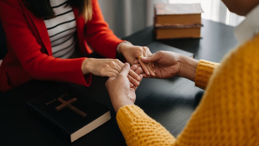 people praying together, hands clasped