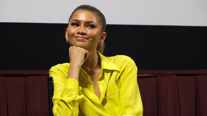 Zendaya smiling resting her chin on her hand