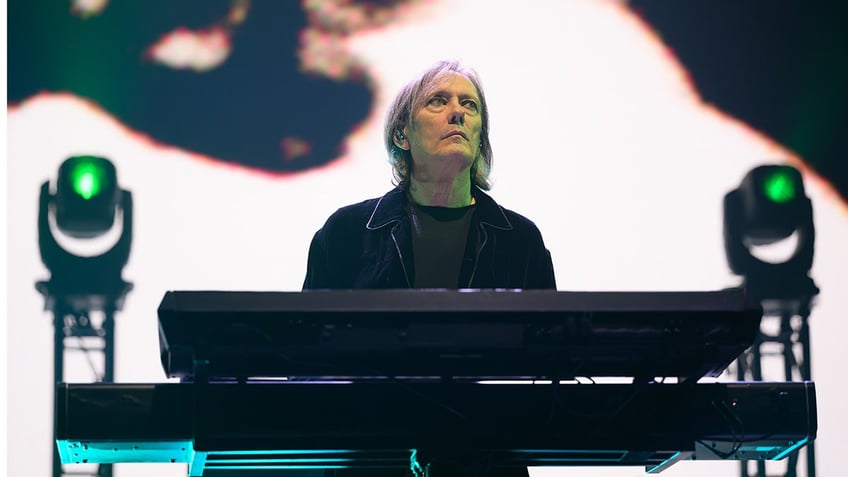 The Cure keyboardist Roger O'Donnell at a keyboard on stage