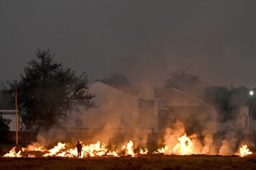 Burning straw stubble, a common but illegal practice in India, sends acrid smoke drifting