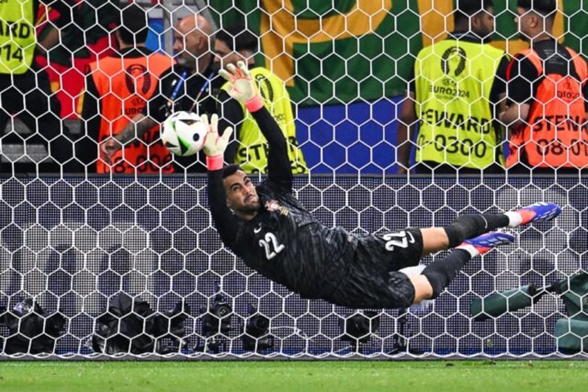 Diogo Costa saves a penalty from Slovenia's Jure Balkovec (unseen) during Portugal's penal