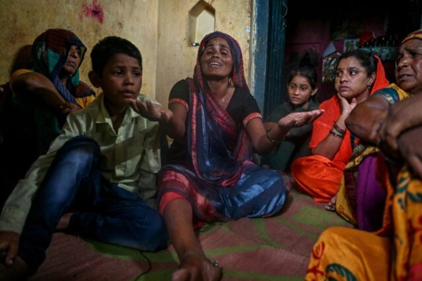 Sudha (C), whose four-year-old son died in a stampede during a sermon , mourns at her resi