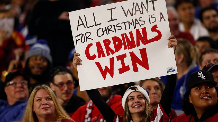 Arizona Cardinals fan holding up a sign at a Christmas game