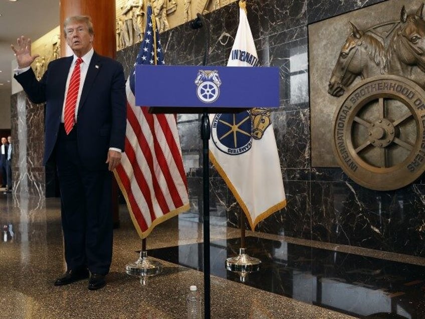 Republican presidential candidate and former President Donald Trump holds up his hand afte