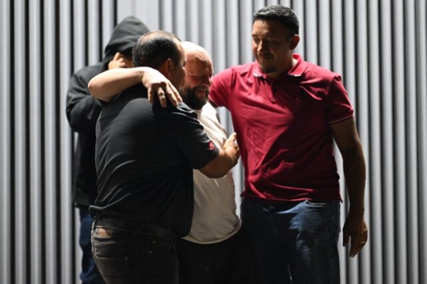 Jose Maximino Amaya (C), a Salvadoran migrant deported from the United States, is received