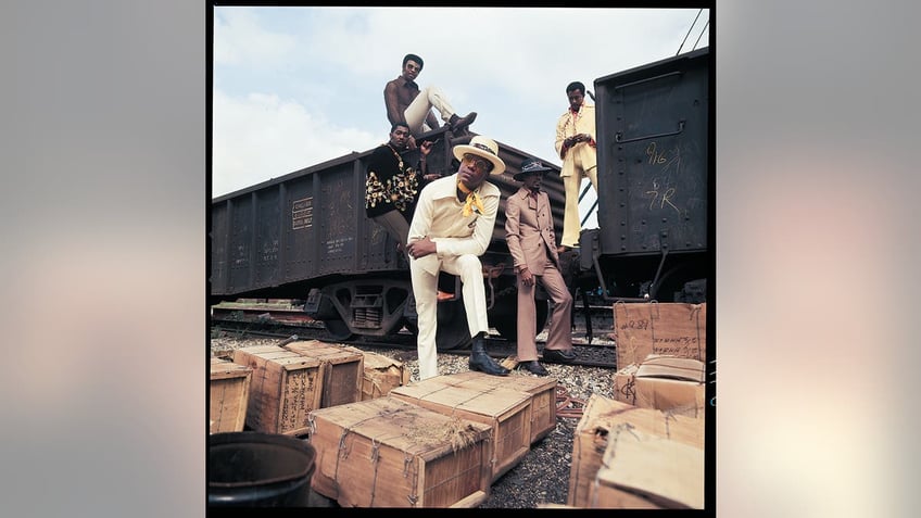 The Temptations posing by a box train.