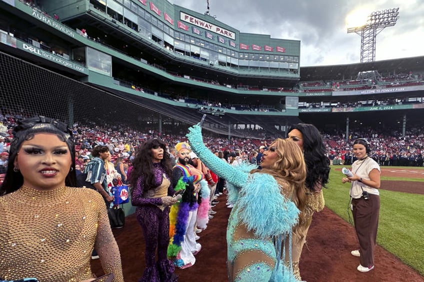 Drag performers take selfies on Pride Night prior to a baseball game between the Boston Red Sox and Philadelphia Phillies, Tuesday, June 11, 2024, in Boston. (AP Photo/Charles Krupa)