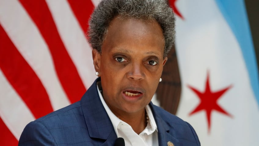 Mayor Lori Lightfoot stands in front of american flag