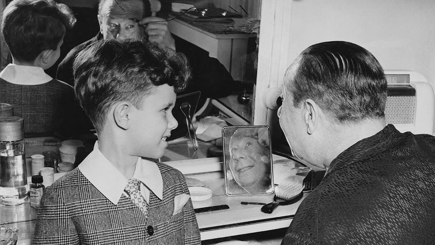 Bert Lahr doing his makeup in front of his son.