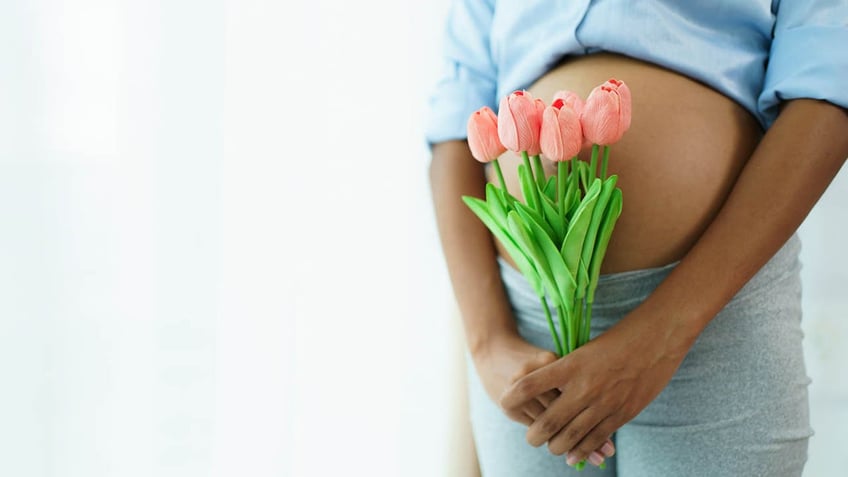 pregnant woman holding flowers