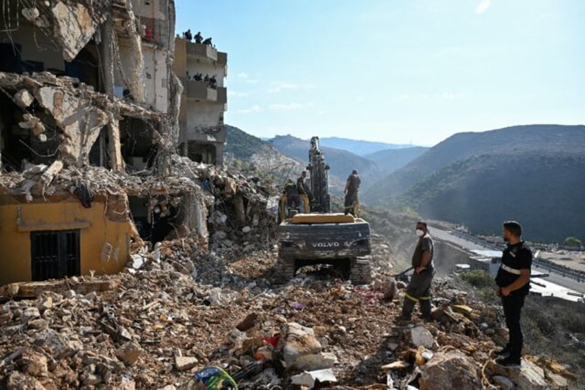 Lebanese emergency services clear the rubble of an apartment block hit by an Israeli strik